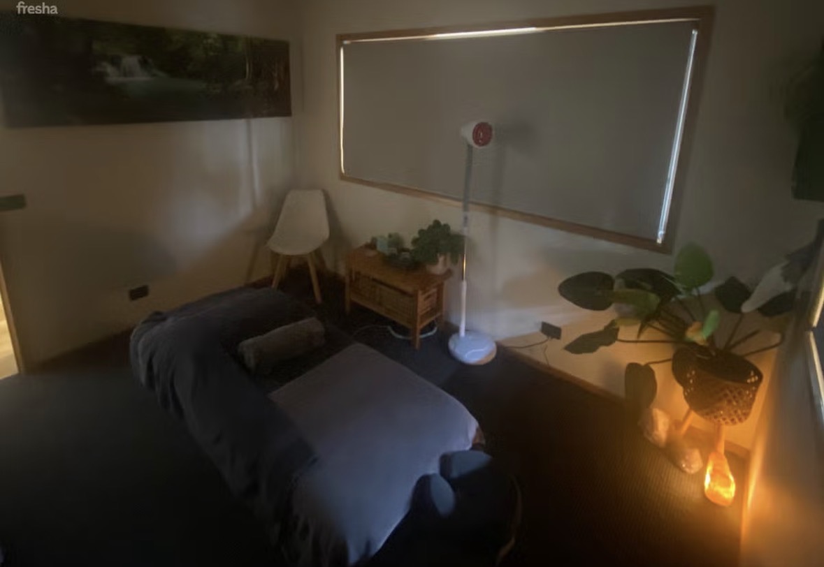 Treatment room with infrared heat lamp, waterfall artwork and greenery